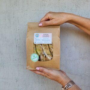 Hands holding a bag of Almond Coconut + Cranberry Rusks